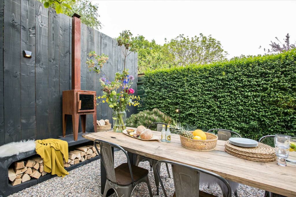 Presentation of a garden table made of wagon planks with iron stove and chairs