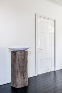 Meerpaal-Präsentationssockel mit Schale in schlichtem Interieur