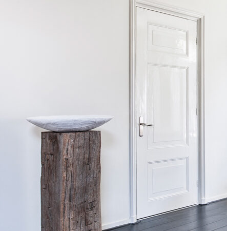 Meerpaal-Präsentationssockel mit Schale in schlichtem Interieur
