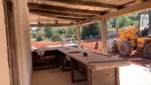 Presentatie van oude eiken balken veranda in aanbouw met graafmachine