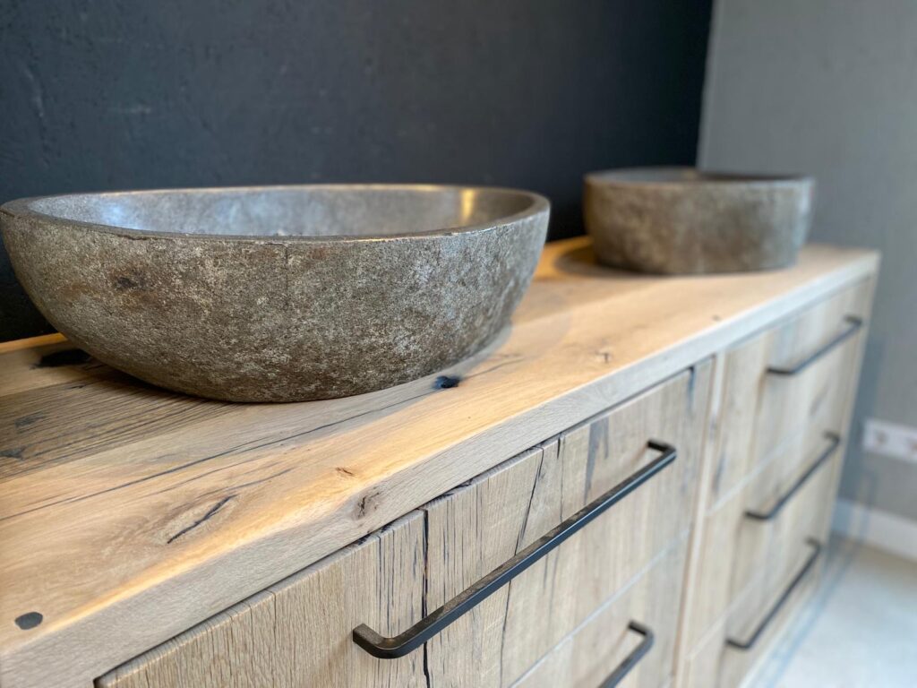 Bathroom furniture made of planed wagon planks with stone bowl