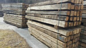 Presentation of multiple batches of old oak beams outdoors