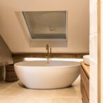 Oude eiken balken in moderne badkamer met bad