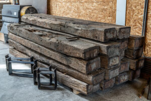Presentation of a pile of whole oak rails blasted with bases presented in the old wood shed for stove