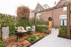 Presentatie van eiken houten balken tuinornament in tuin met houten vlonder