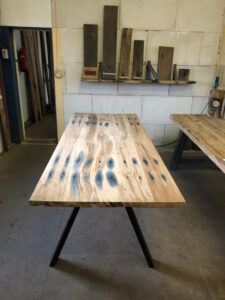 Presentation of oak table made of railroad sleepers with steel 2 leg photographed in old wood shed