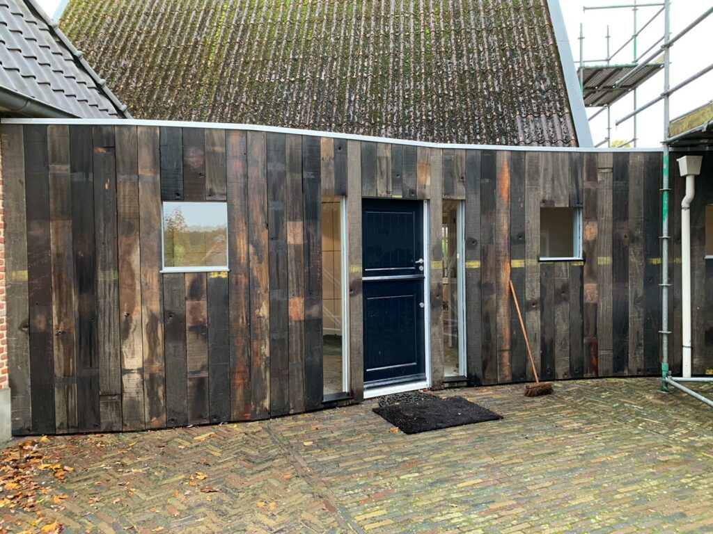 exterior facade clad with double hardwood wagon planks dark