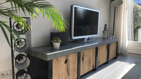 Presentatie van betonnen tv meubel met kastjes van eiken wagonplanken in huiskamer