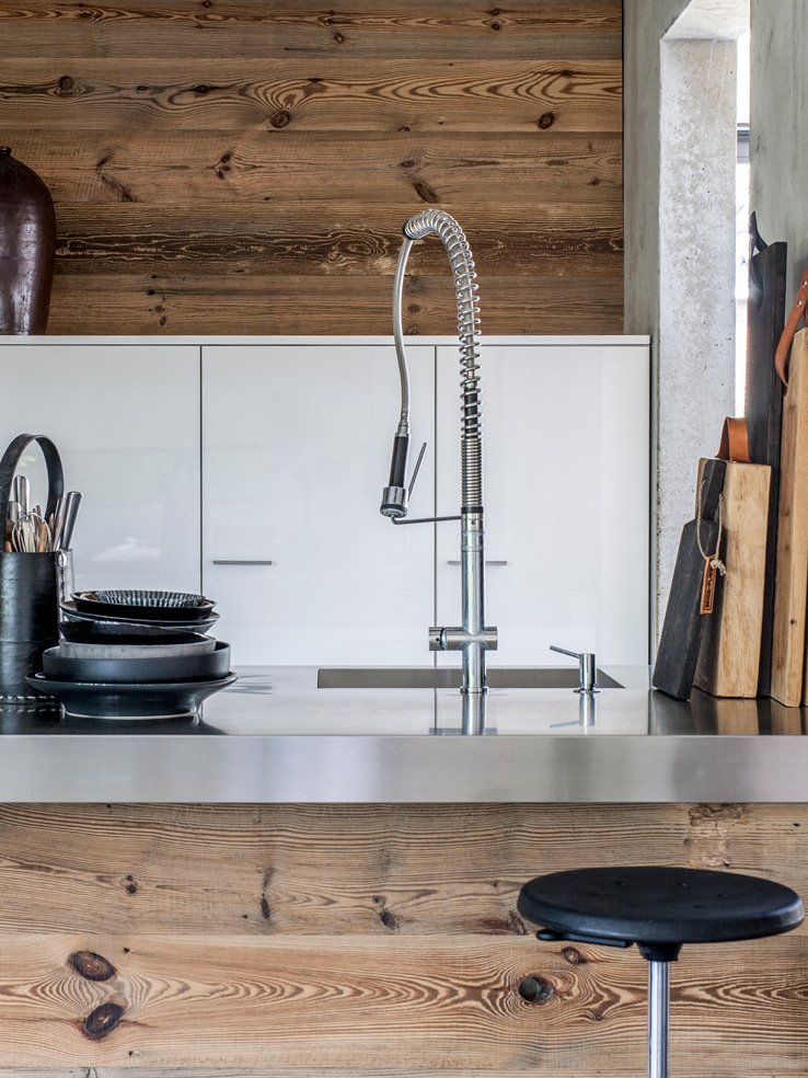 Moderne Küchenpräsentation aus braunem Tannenholz mit Barhocker und Spülbecken