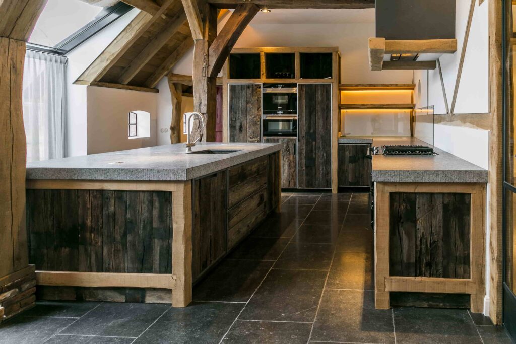 Presentation of two kitchen blocks made of old oak wagon parts with oak beams and gray kitchen top
