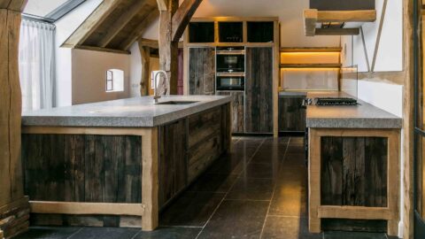 Präsentation von zwei Küchenblöcken aus alten Eichenwagenteilen mit Eichenbalken und grauer Küchenplatte