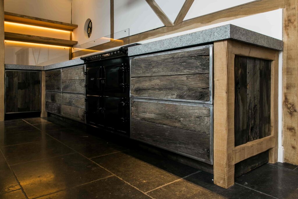 Presentation kitchen with oak beams, fronts of brushed wagon planks and concrete top