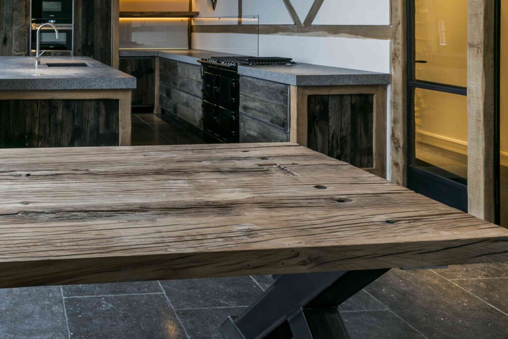 Presentation of planed oak wagon planks 6cm thick with black steel x-leg in kitchen