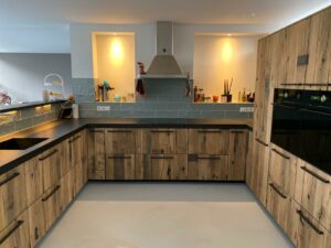 Presentation of entire kitchen with panels of wagon planks combined with black kitchen top