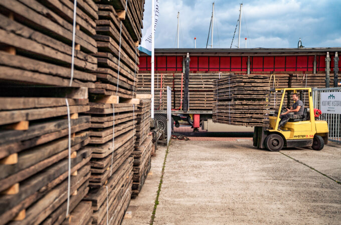 Grote partij onbewerkte wagonplanken uitladen met heftruck