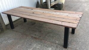 Outdoor table made of hardwood wagon planks with square steel legs
