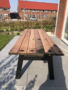 Outdoor table in garden of hardwood with steel frame