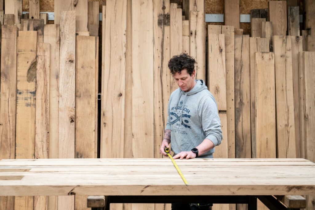 Bezoeker oud hout loods zoekt blokwanden op maat uit