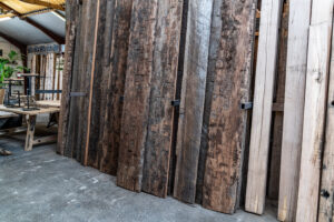 Präsentation verschiedener Anlegepfahlkappen bis zu 4 Metern, die im alten Holzschuppen stehen