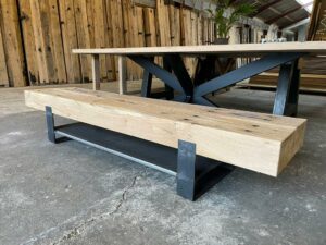 Presentatie van een eikenhouten tv meubel van geschaafde spoorbielzen diagonaal gefotografeerd in oud hout loods