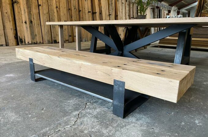 Presentatie van een eikenhouten tv meubel van geschaafde spoorbielzen diagonaal gefotografeerd in oud hout loods
