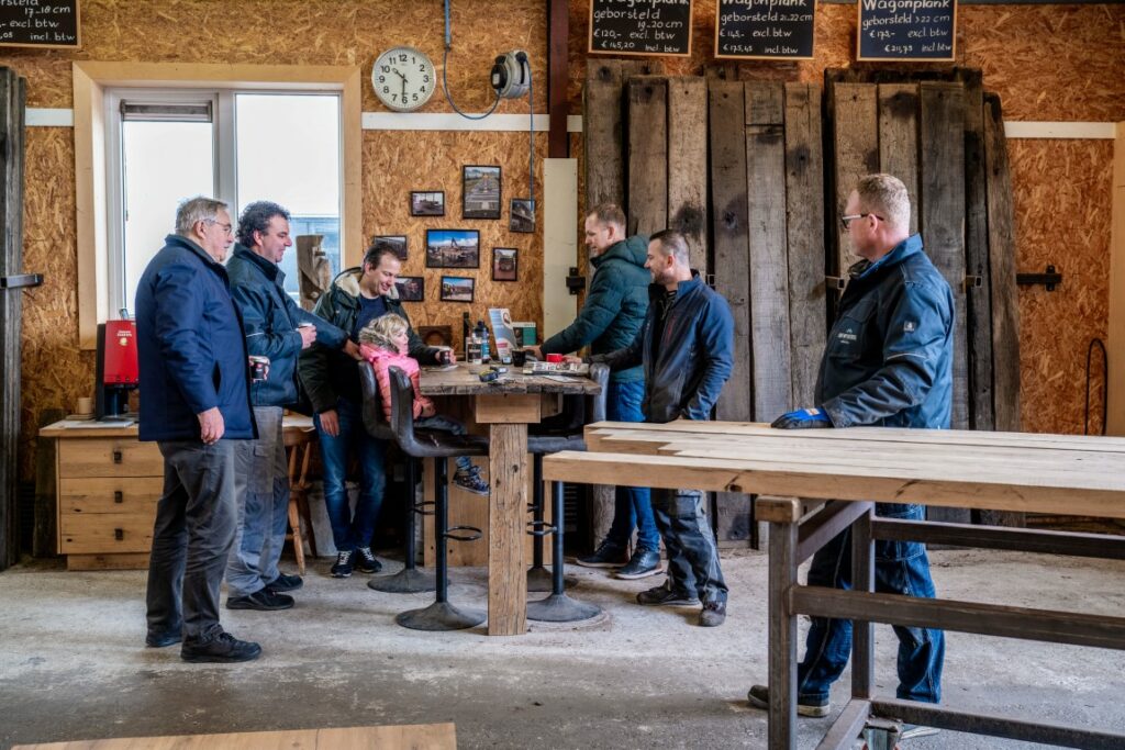 Customers consult on wood at bar table