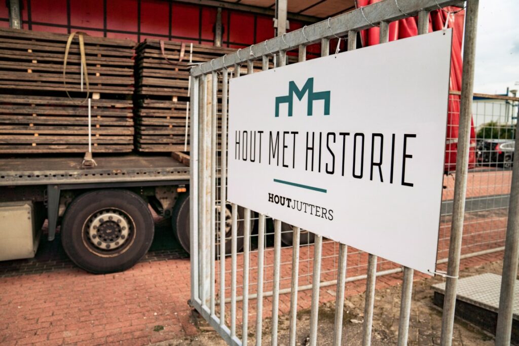 Groothandel oud hout vrachtwagen bij bord hout met historie
