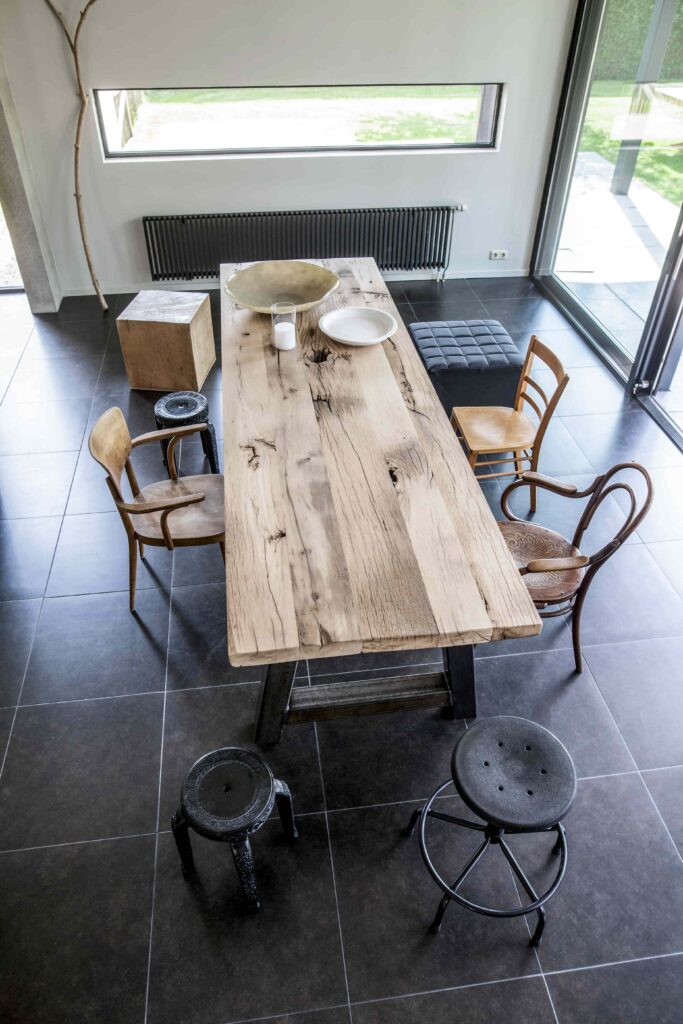Präsentation eines 6 cm dicken Blockwandtisches in einem modernen Wohnzimmer mit verschiedenen Stühlen